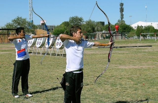  two young people practicing archery 